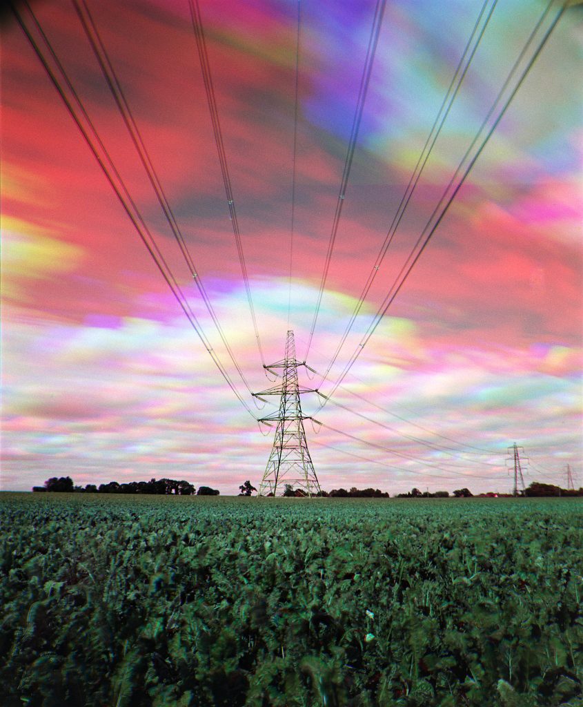 Trichrome photo of Steel tower with psychedelic coloured skies