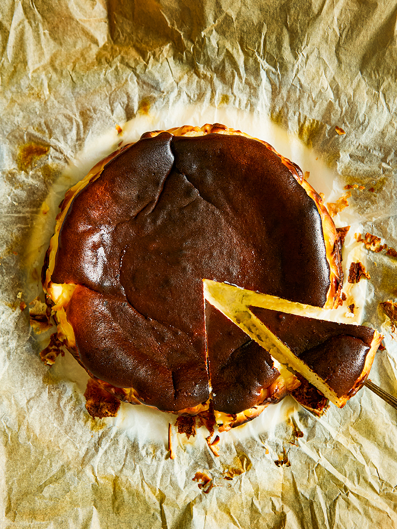 brown cake with a slice cut on a beige baking paper