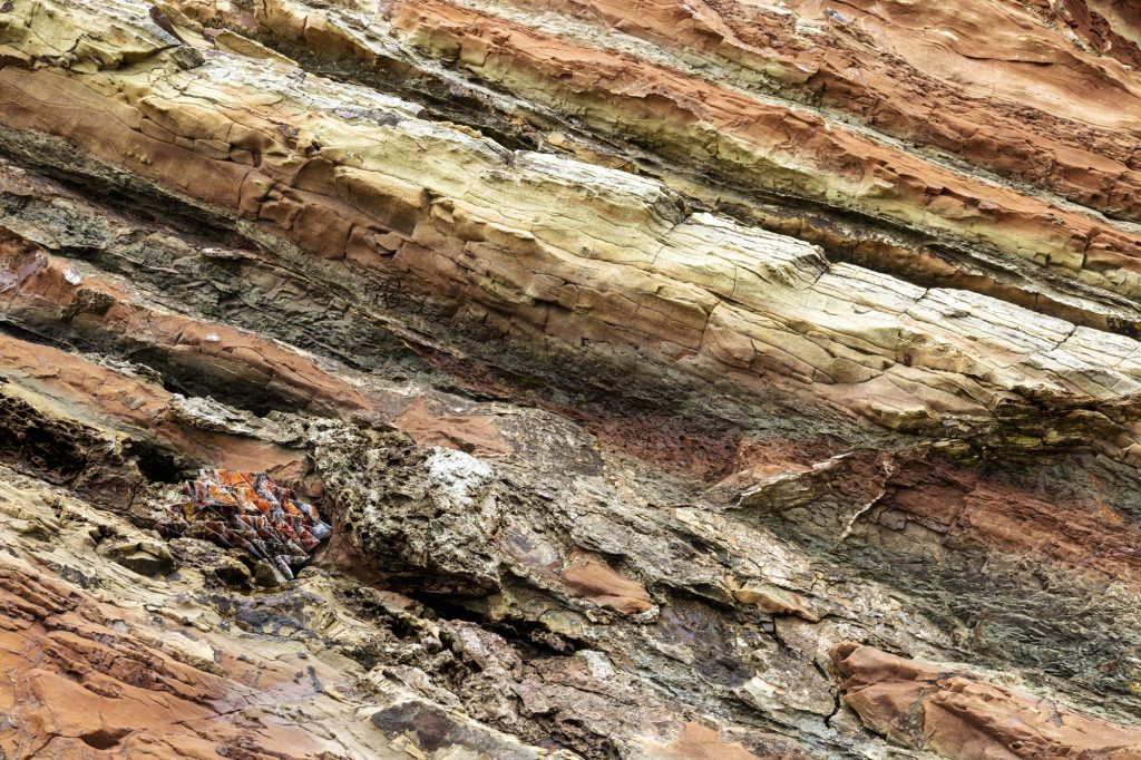 Image of an intricately-folded photograph camouflaged in a geological formation.