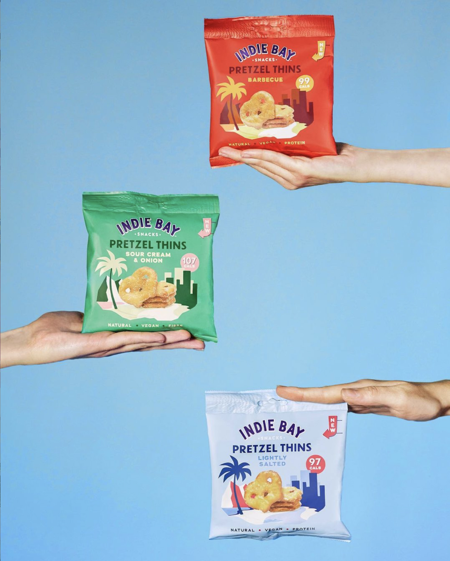 3 hands holding bags of pretzels
