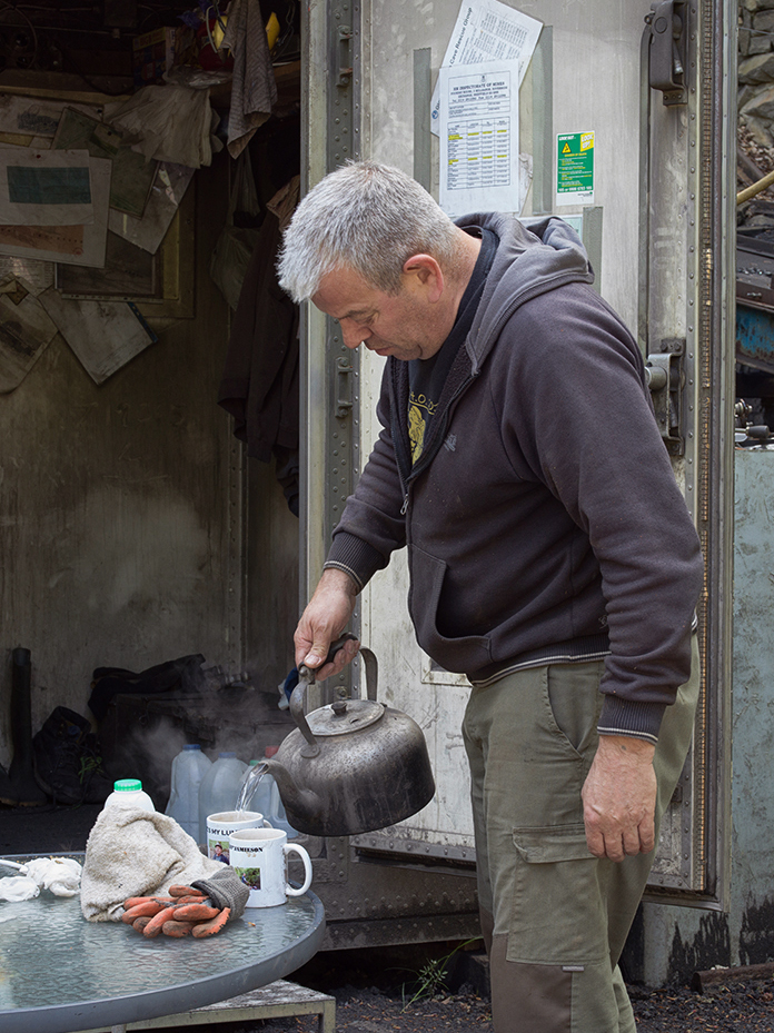 Miner pouring hot water into tea mug