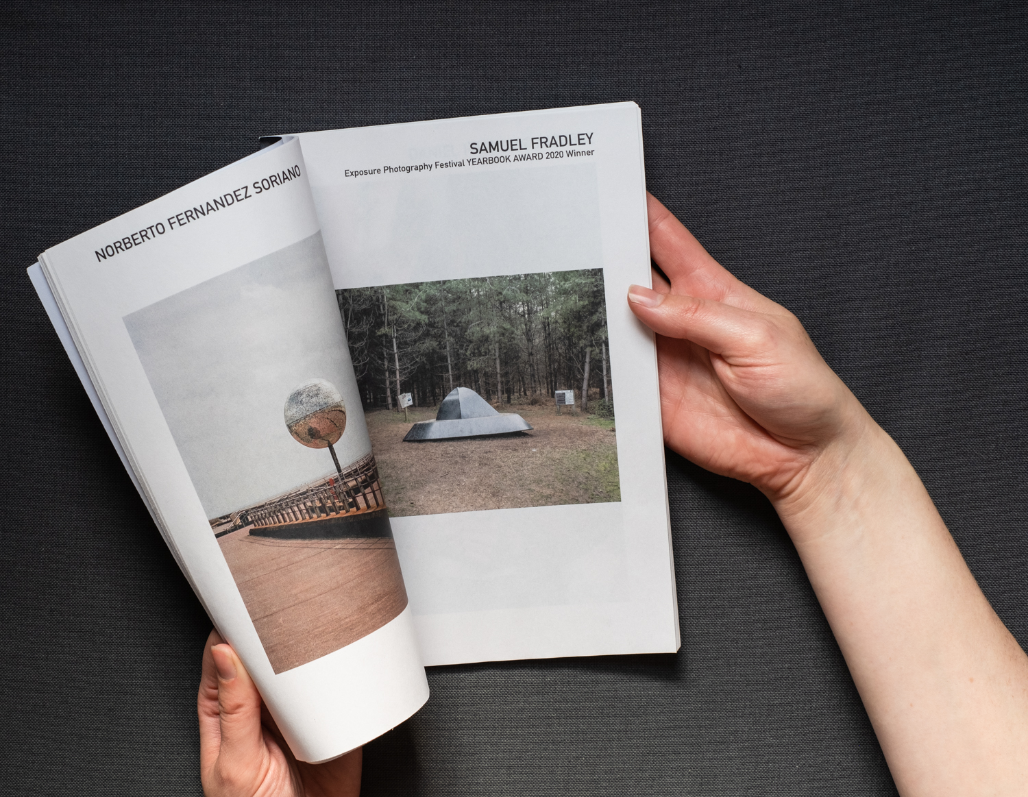 Hands flicking through the YEARBOOK 2020 printed publication, against a grey background.