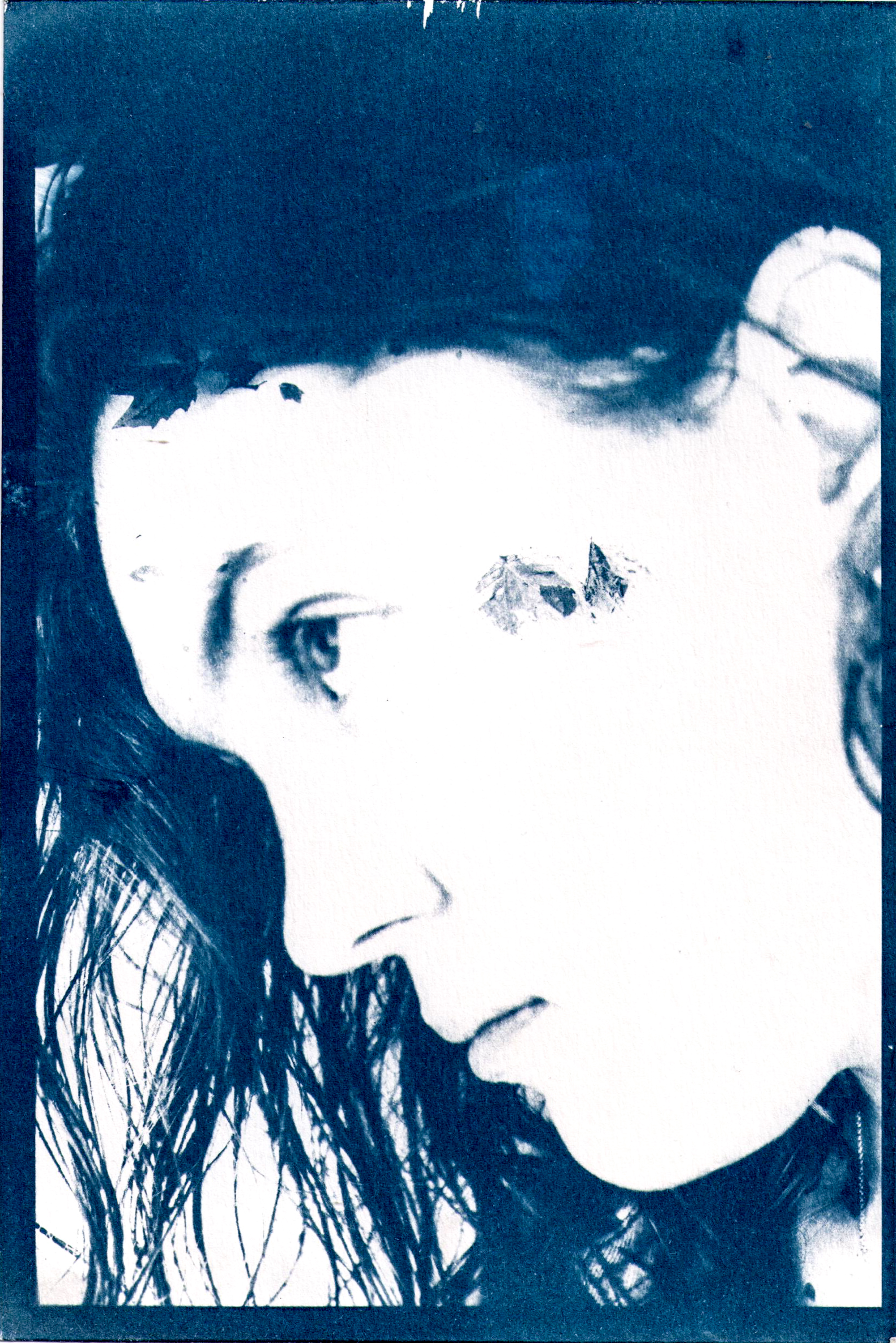Side profile photo of a female with double exposure of leaves on water.